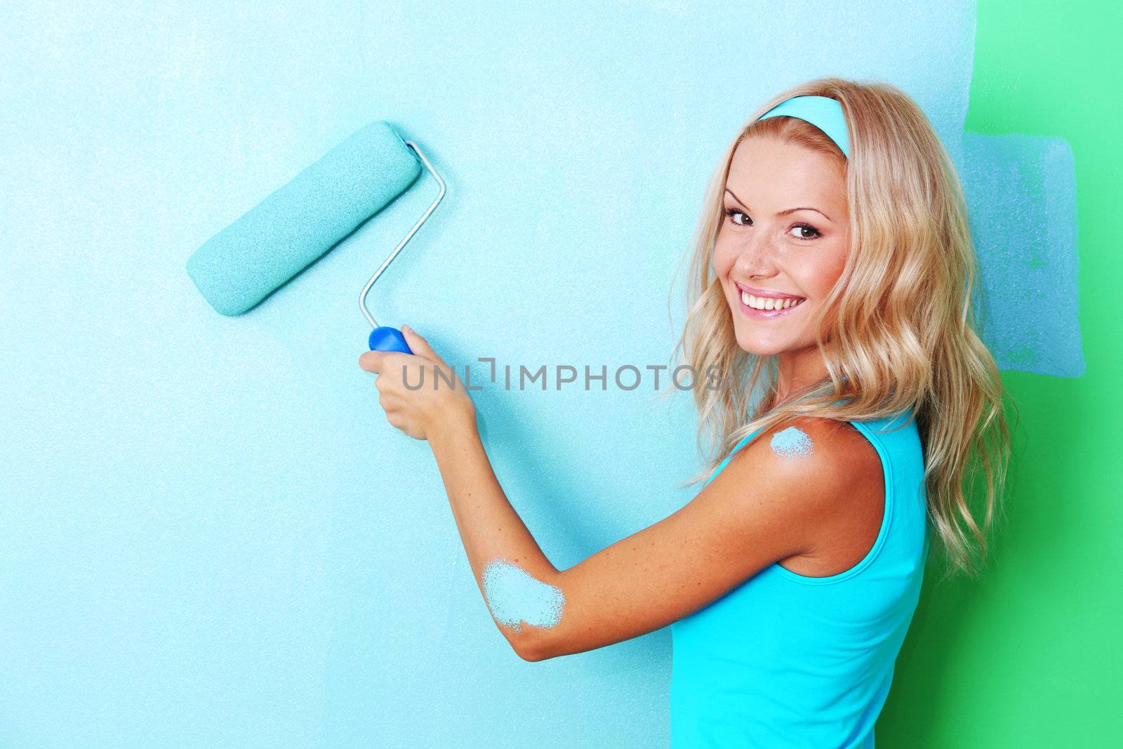 woman paints the wall roller