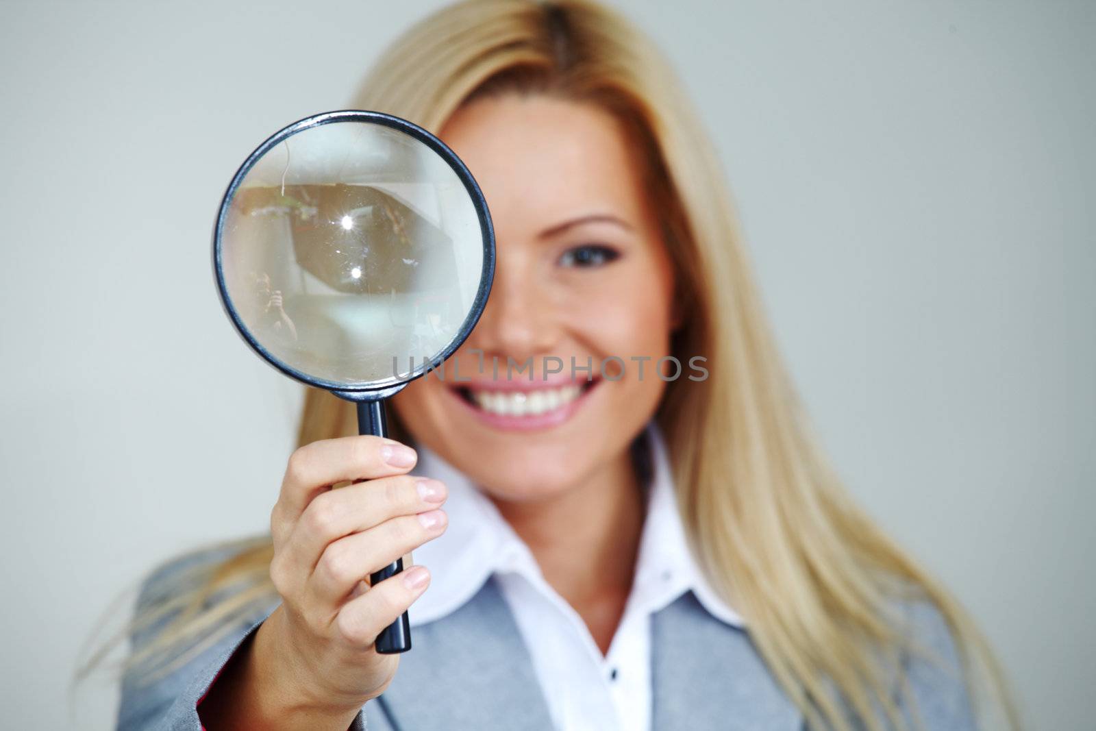 business woman looking through a magnifying glass