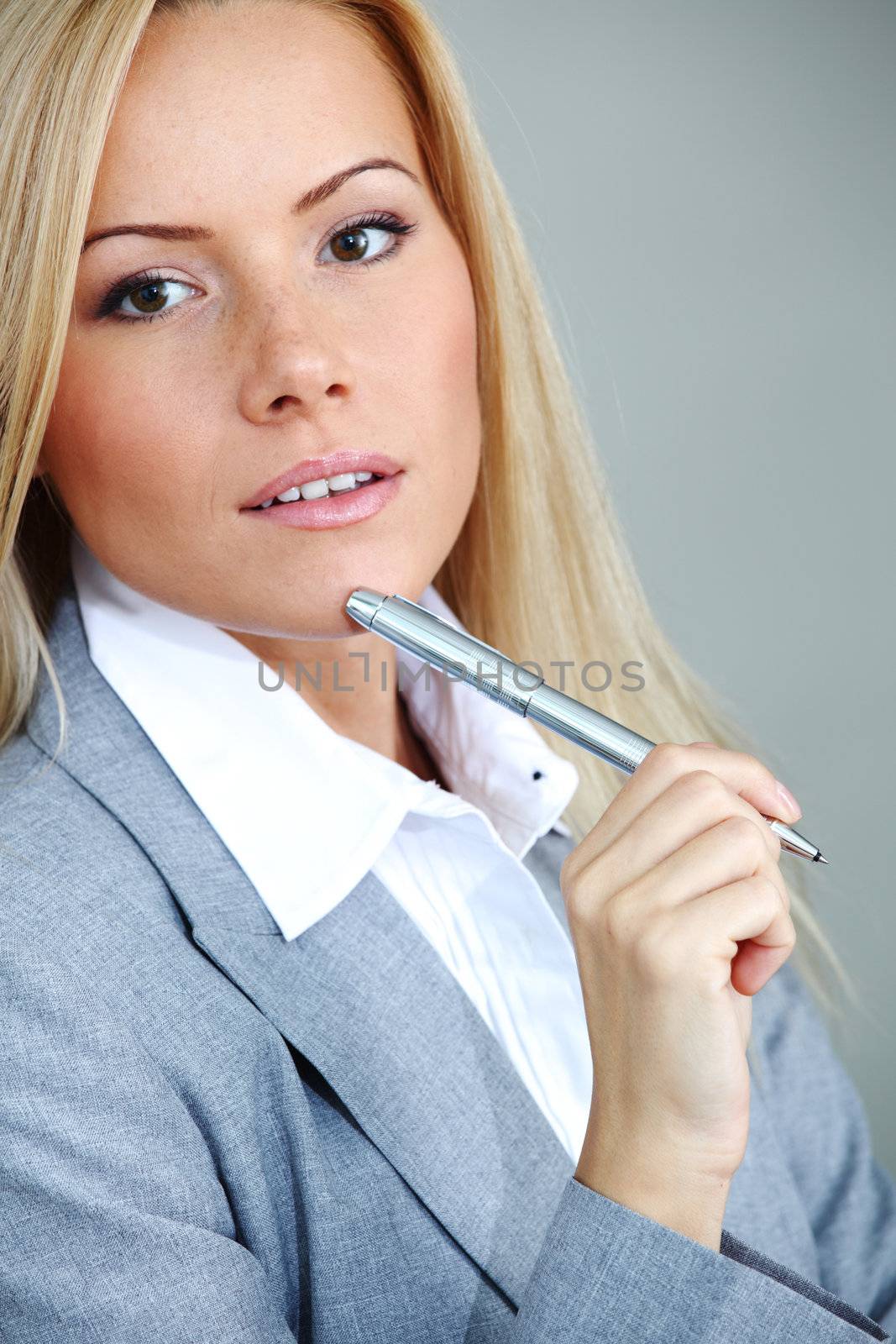 business woman on gray background  pen in hands