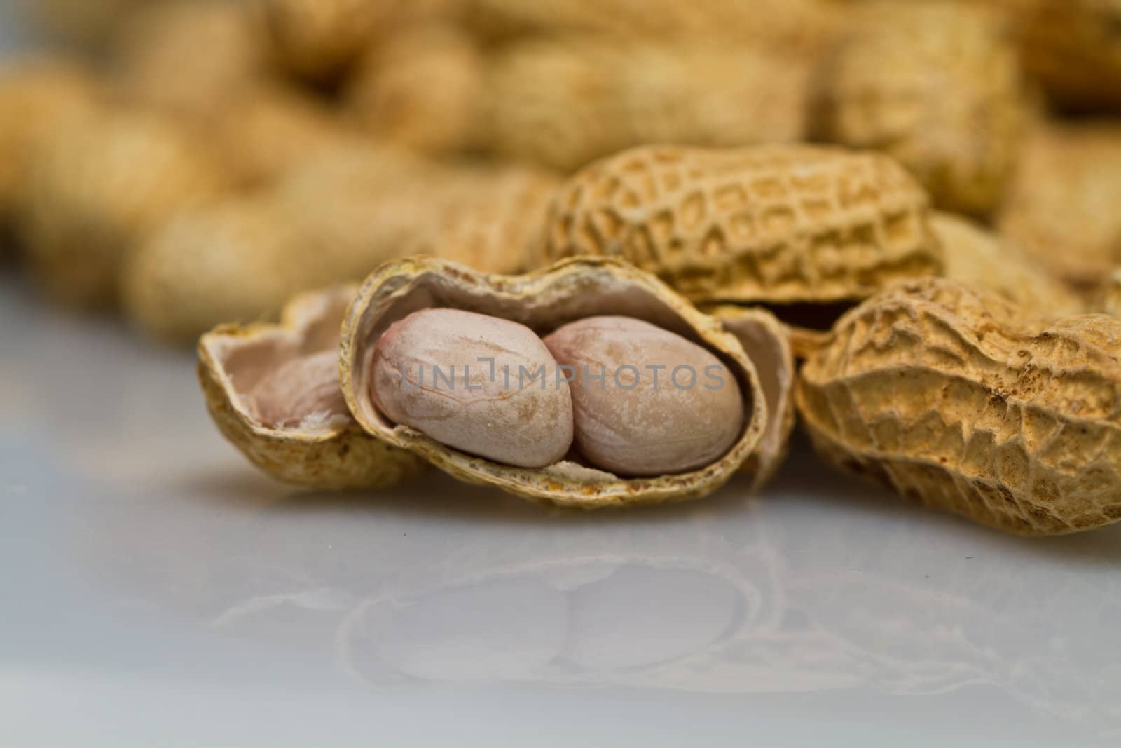 Close up view of an opened groundnut with mirror image in landscape orientation as abstract background