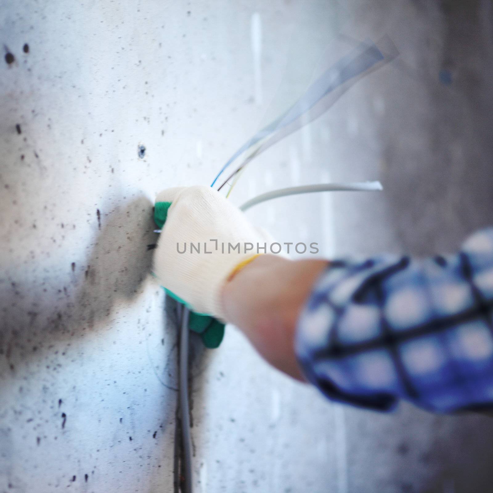 worker puts the wires in the wall