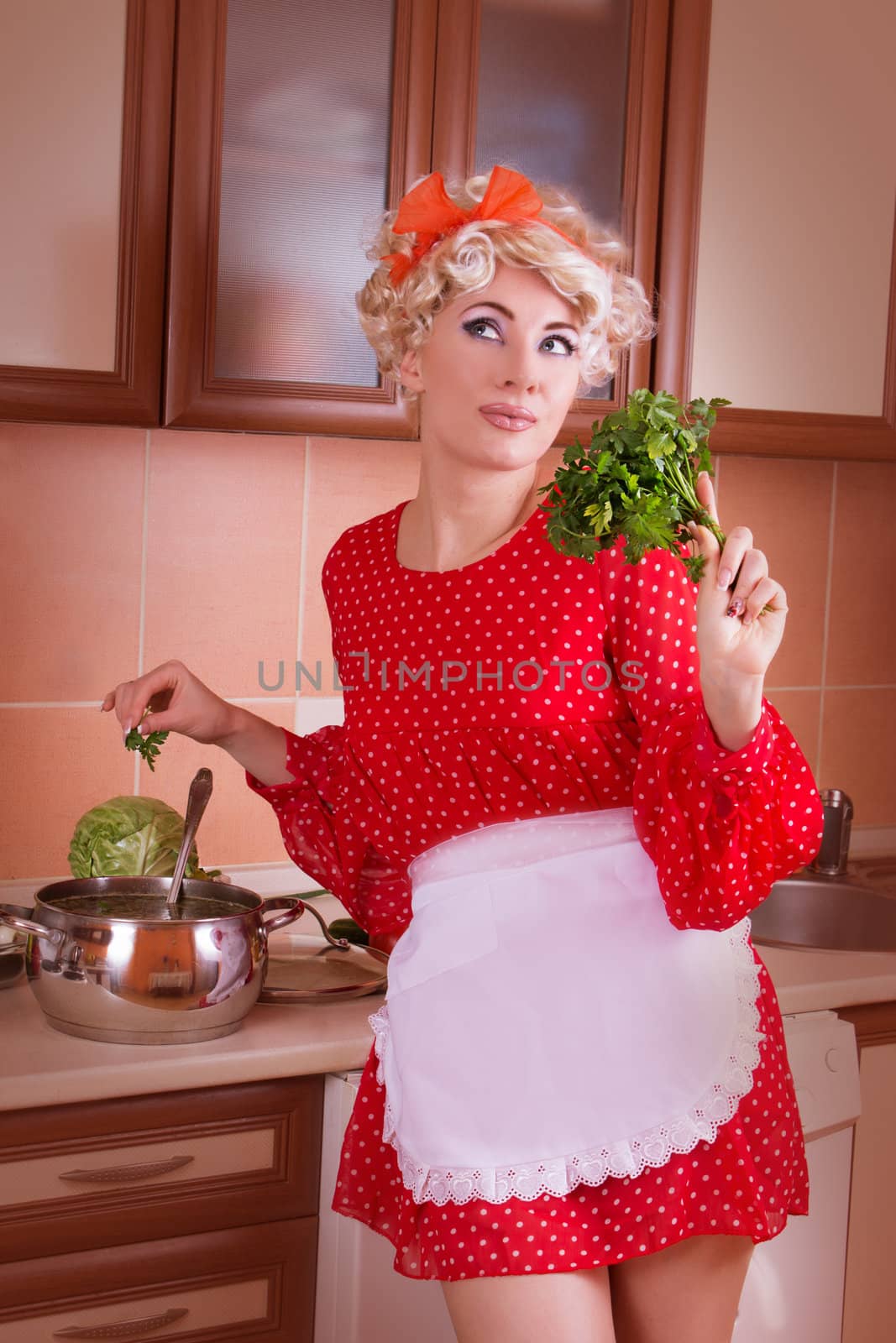 Pinup woman with greens cooking soup on kitchen