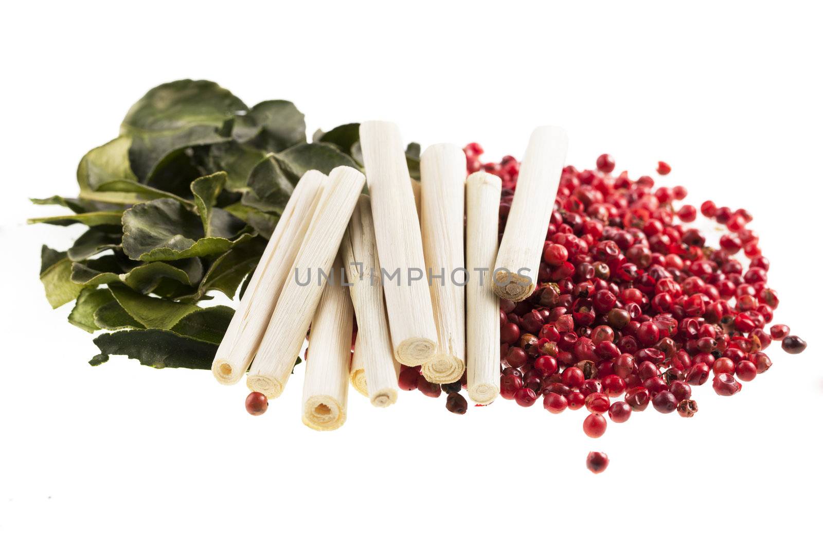 Thai cooking spices, kaffir lime leaves, lemon grass and pink peppercorns isolated on a white background