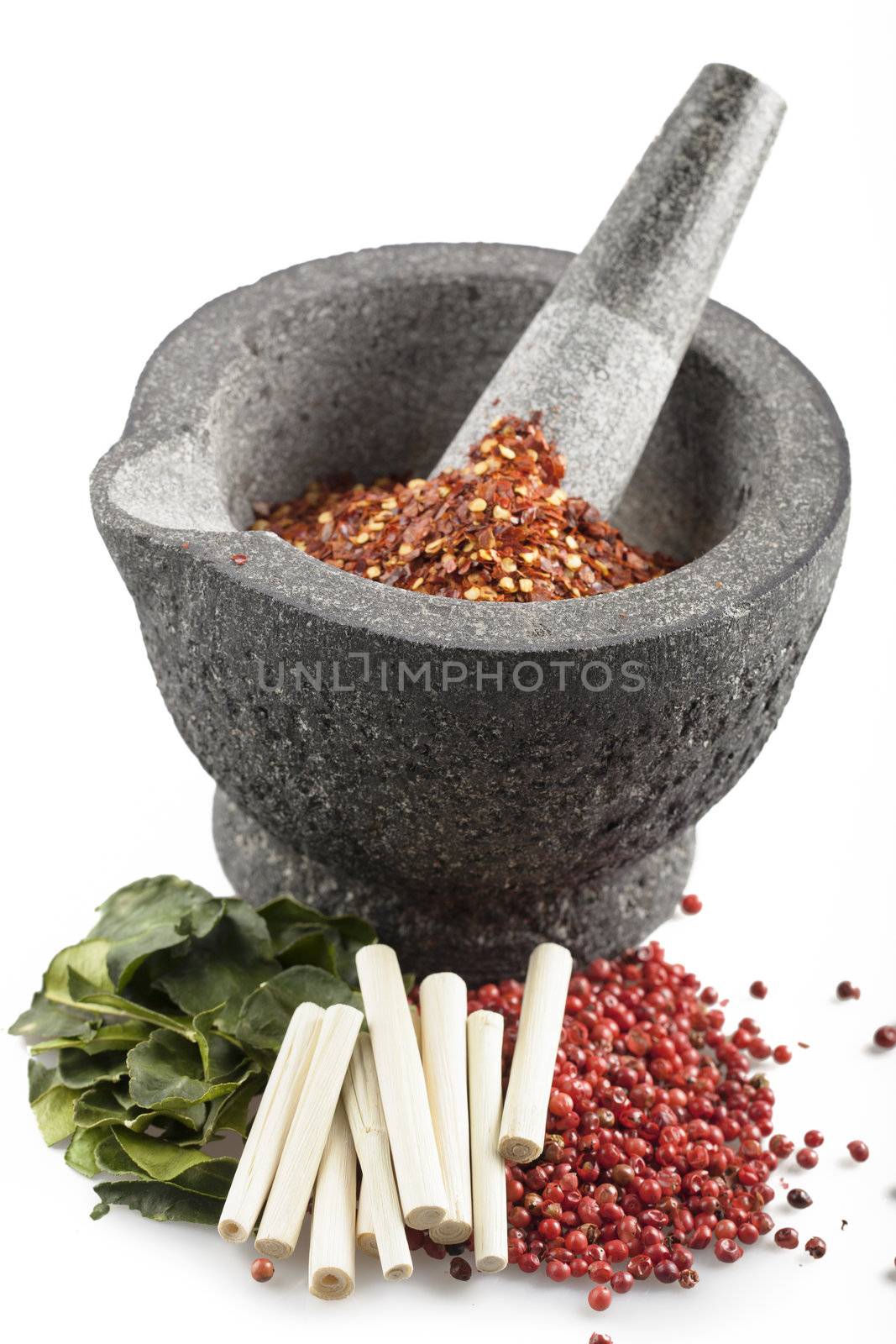 Kaffir lime leaves, lemon grass, pink peppercorns and a mortar and pestle with crusthed pepper.