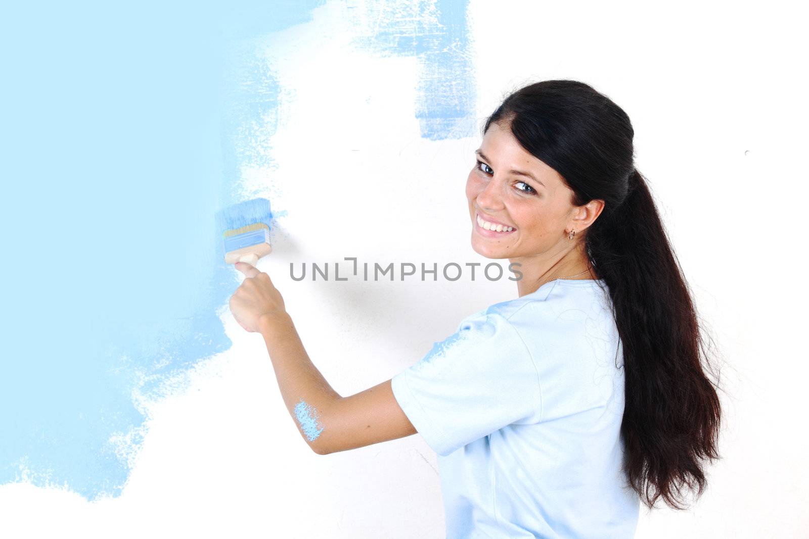 woman paints the wall brush