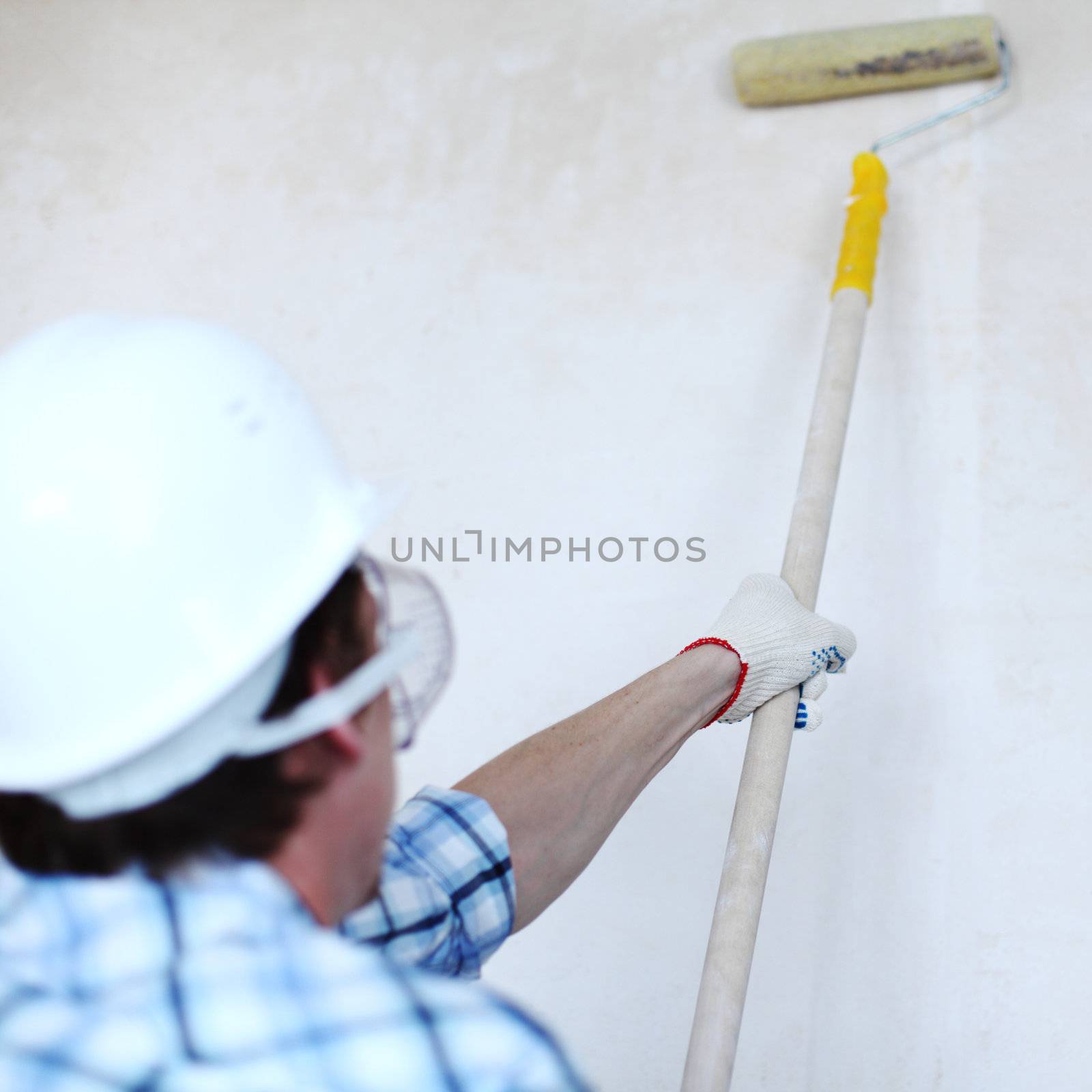 worker spends anchor roller on the wall