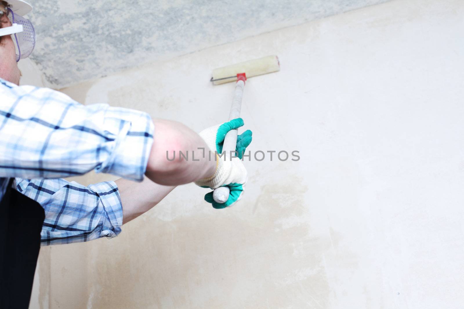 worker spends anchor roller on the wall