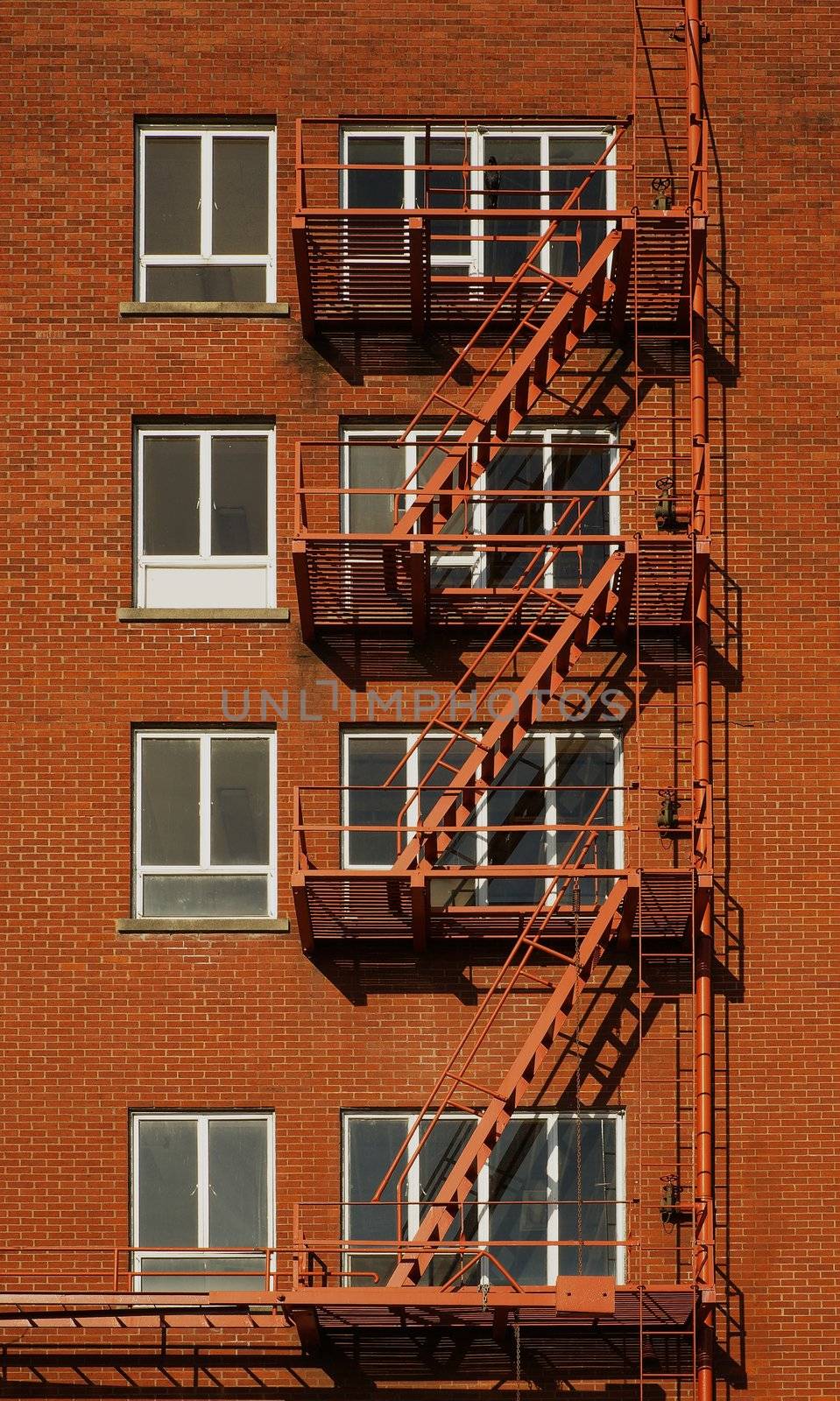 Red brick building with four rows of windowed fire escapes