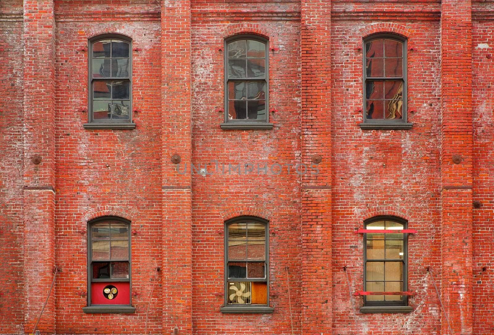 Three columns of windows on an old brick walled building
