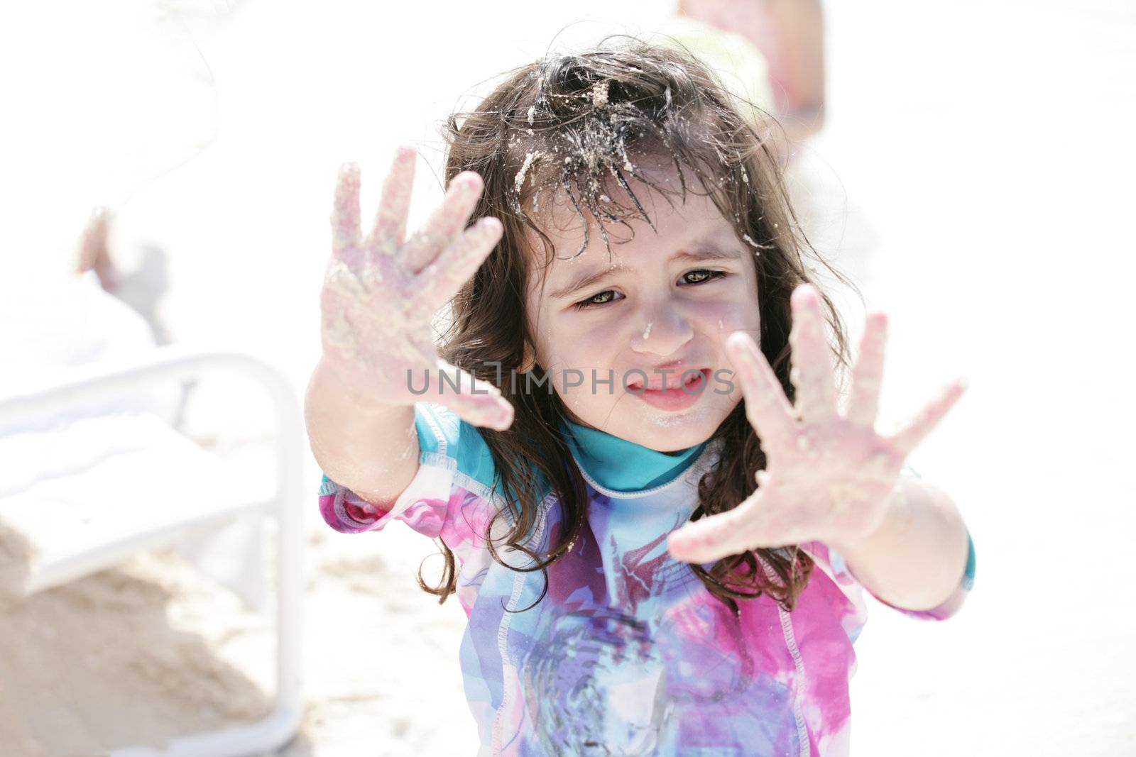 Little girl playing with sand. by dacasdo