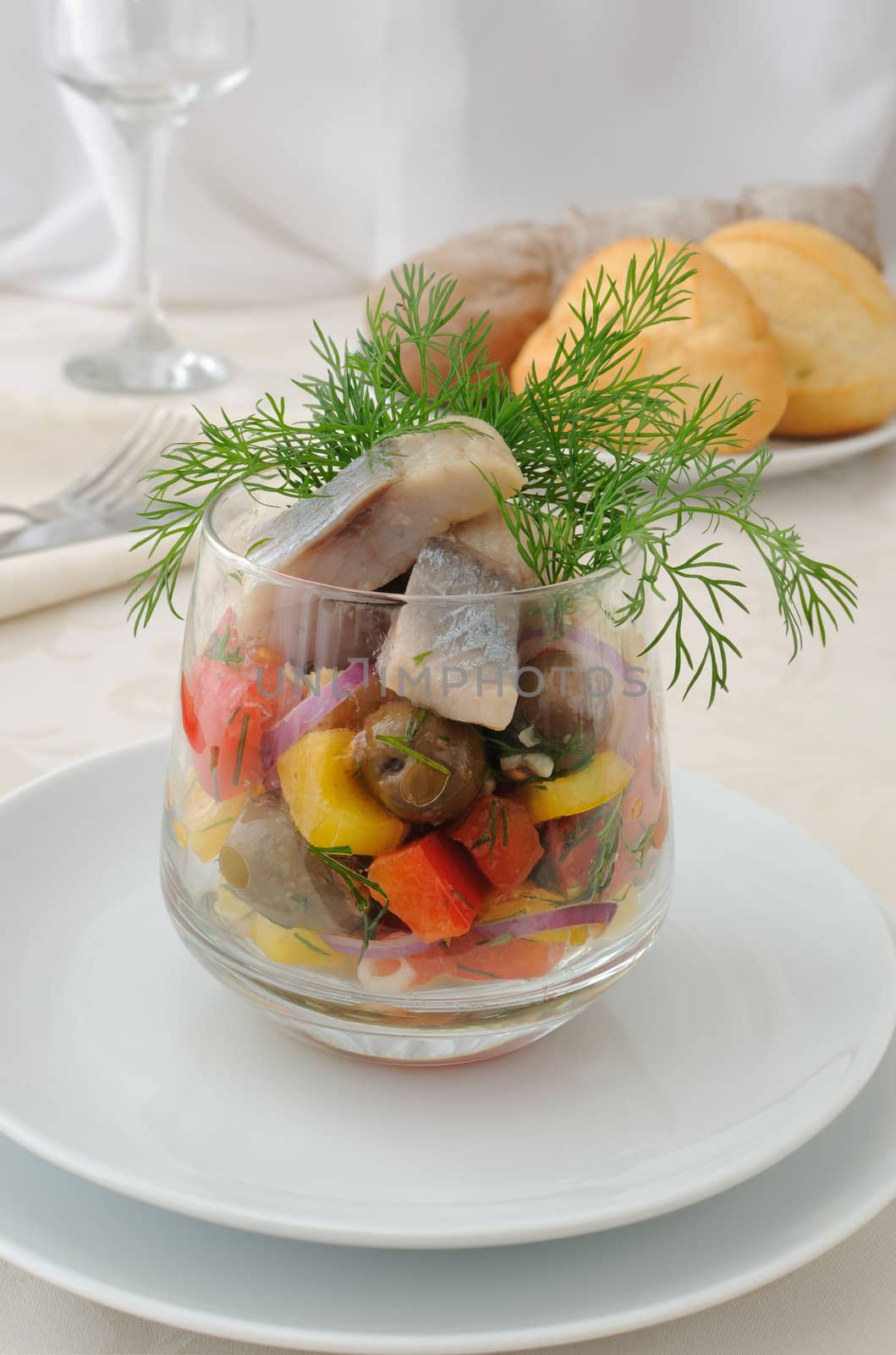 Salad with pieces of herring, white bread with vegetables and herbs
