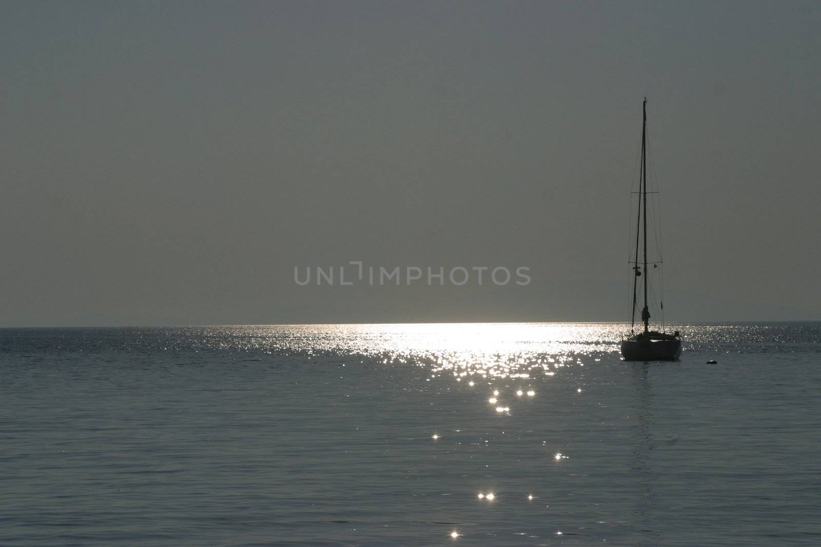 Boat sailing away at sundown