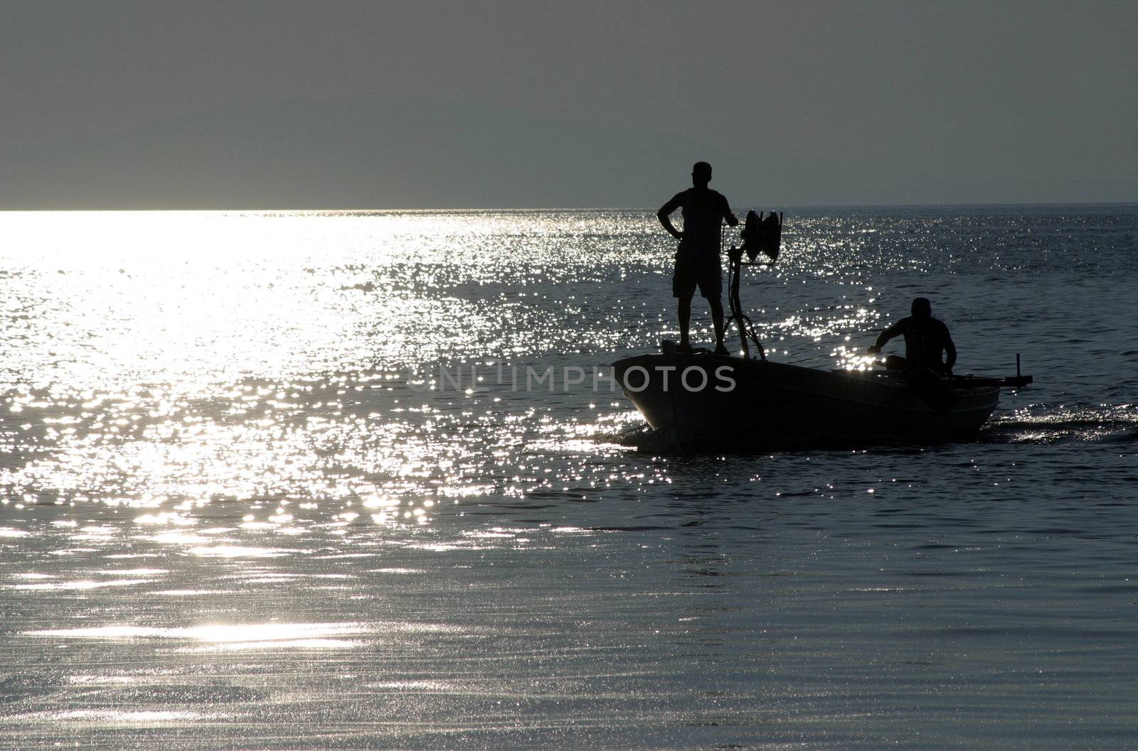 Boat sailing away at sundown