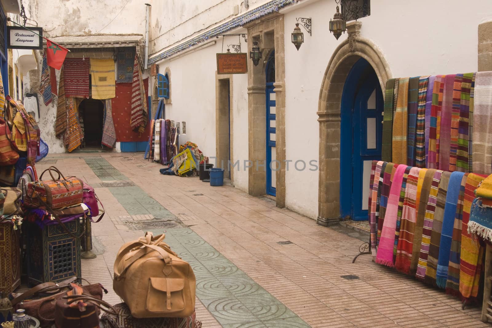 Shops selling local craft products in a narrow street in the fishing village of Essaouira, Morocco.