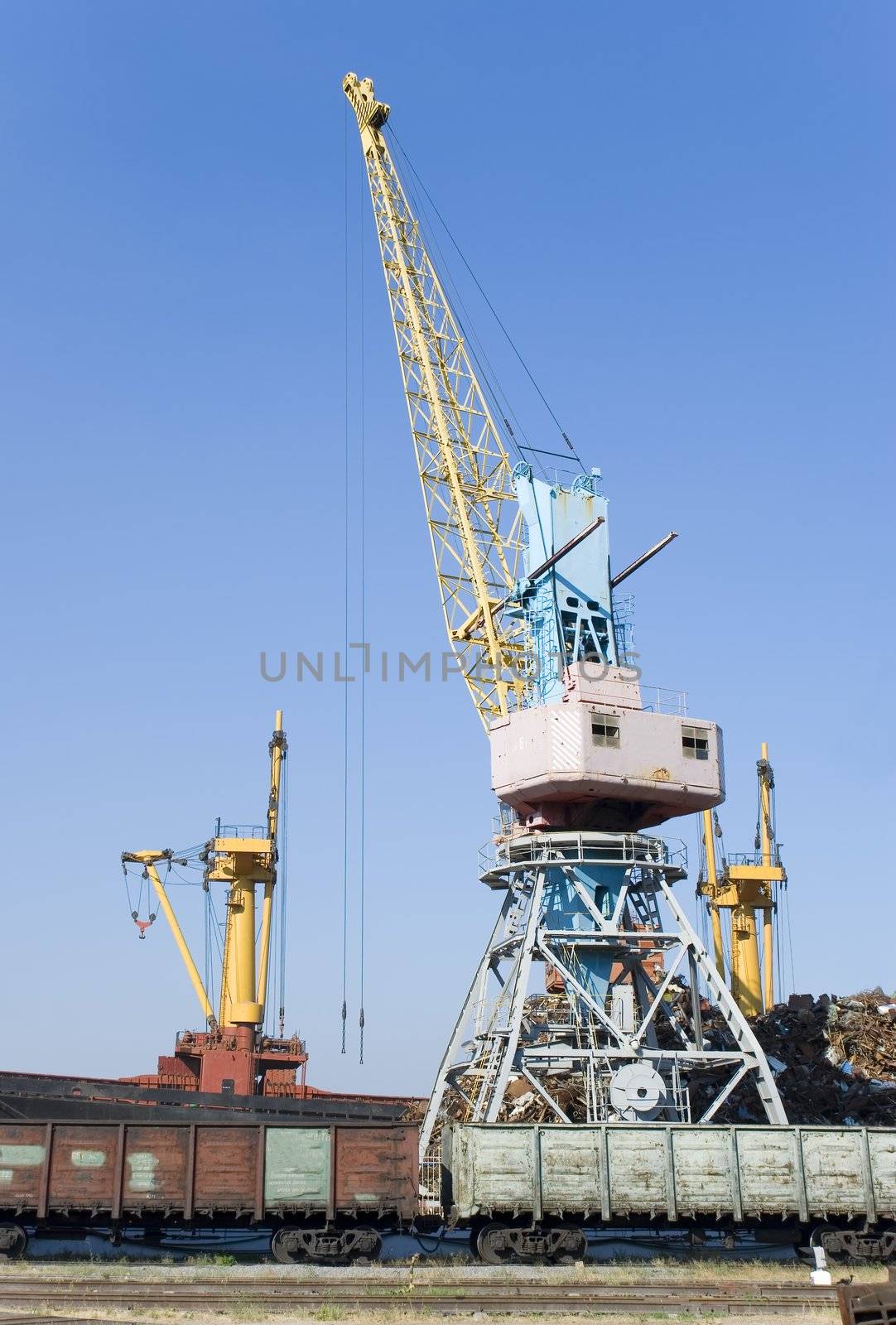 The elevating crane costing on loading of cars on a railway way 