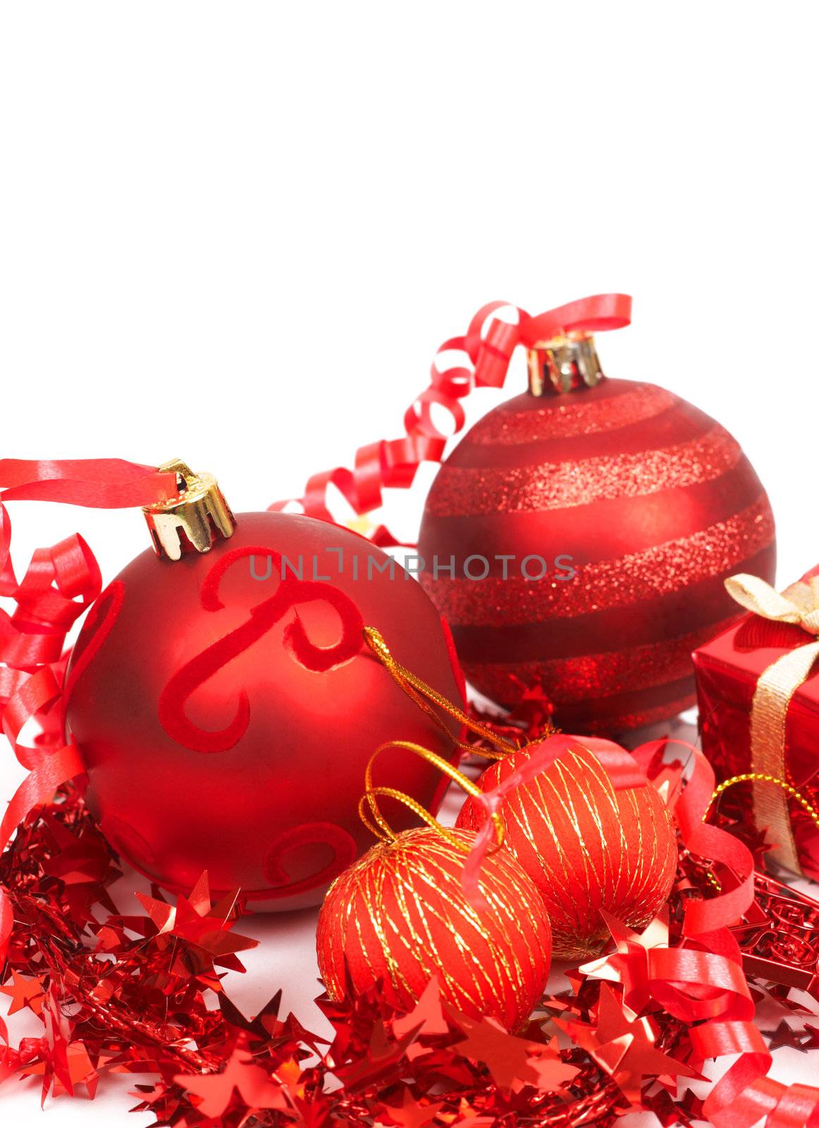Four red Christmas baubles and gift box isolated on white background with copy space. 