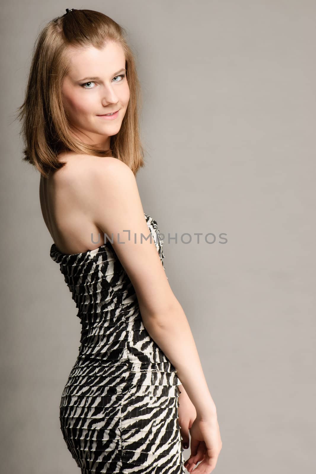 Blue eyed girl with zebra dress isolated on gray