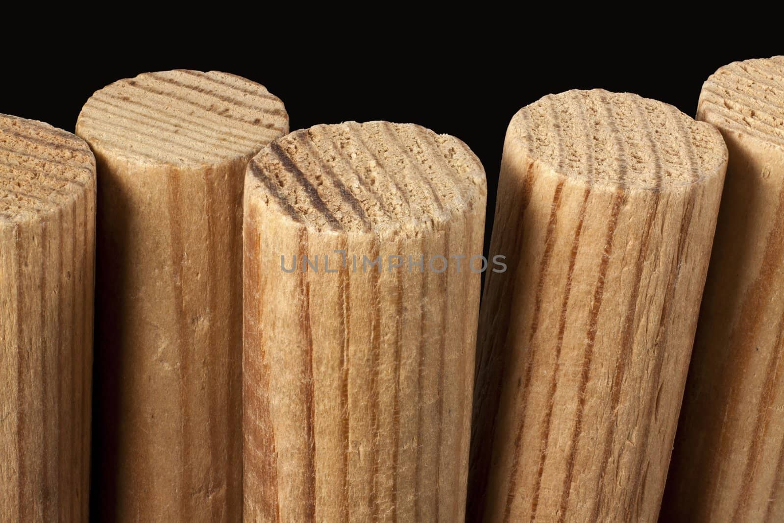A row of wooden columns on a black background