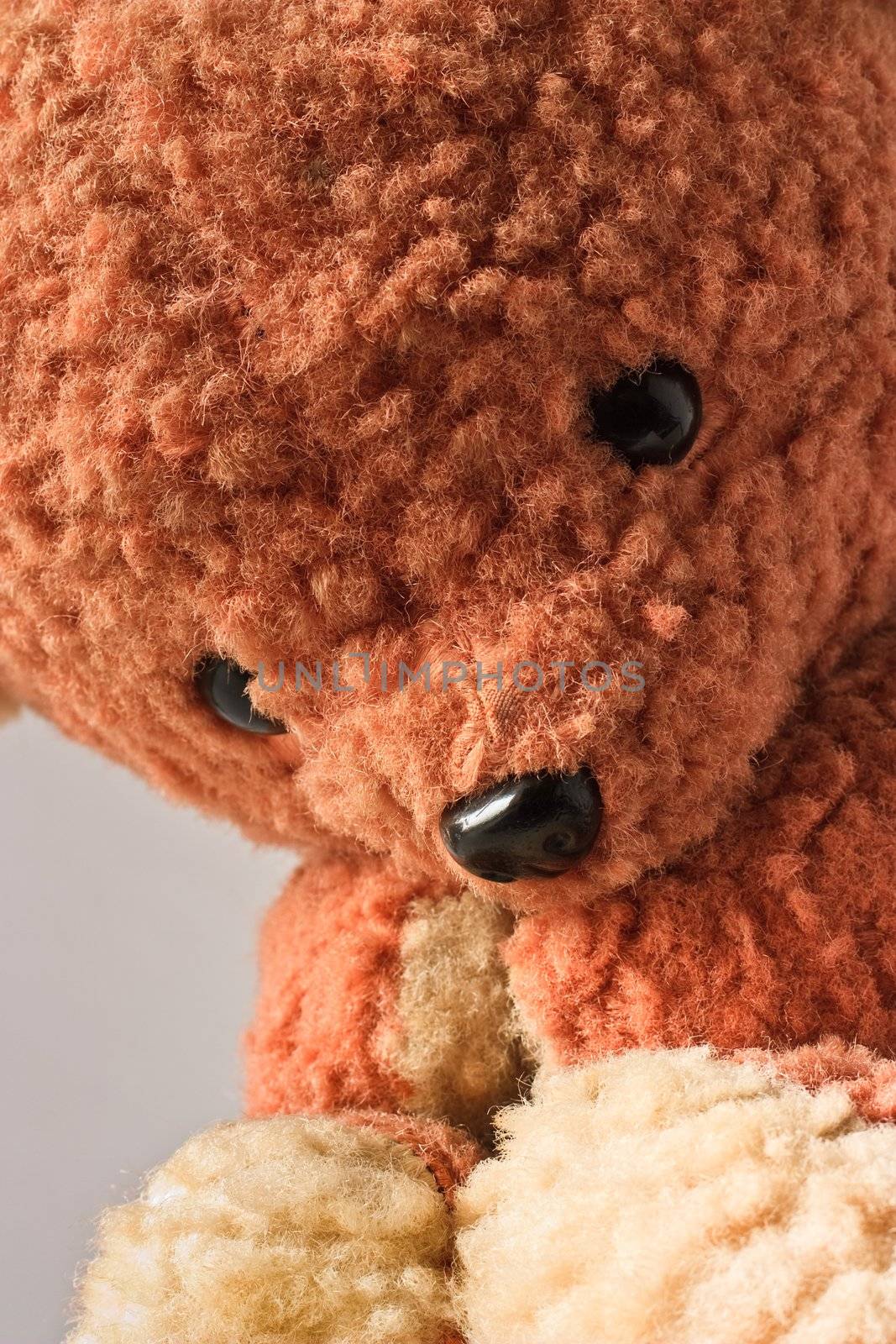 Sad brown teddy bear sitting and looking down