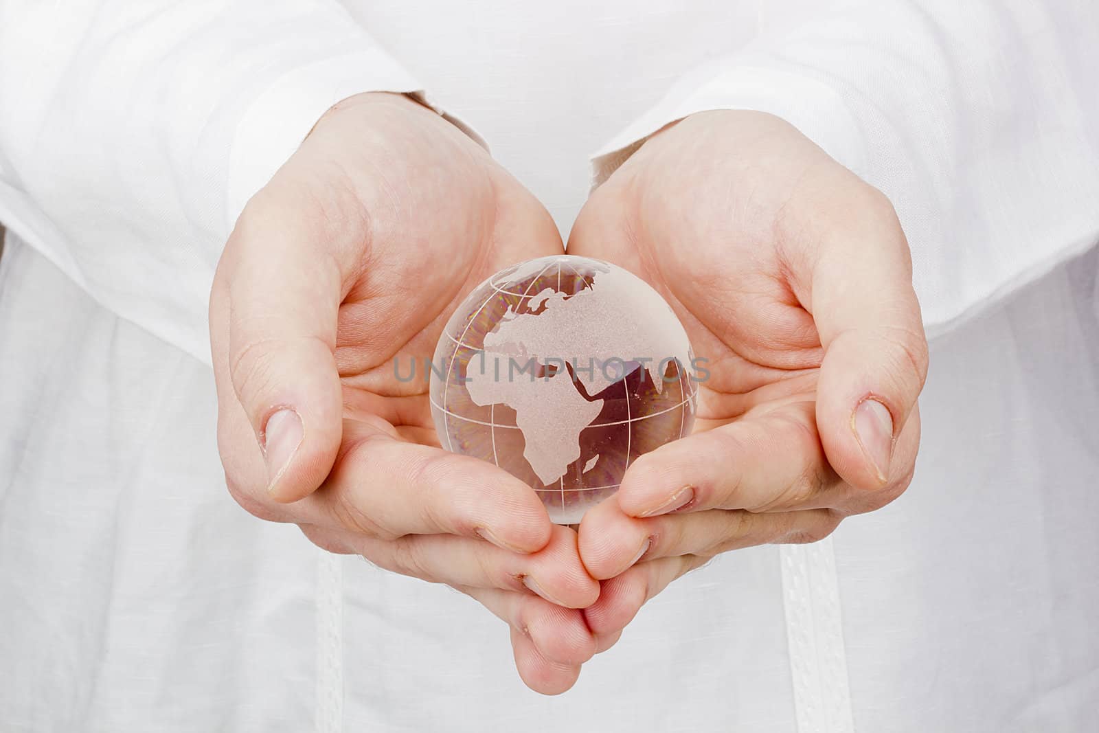 Close-up photograph of a glass globe in man's hands.