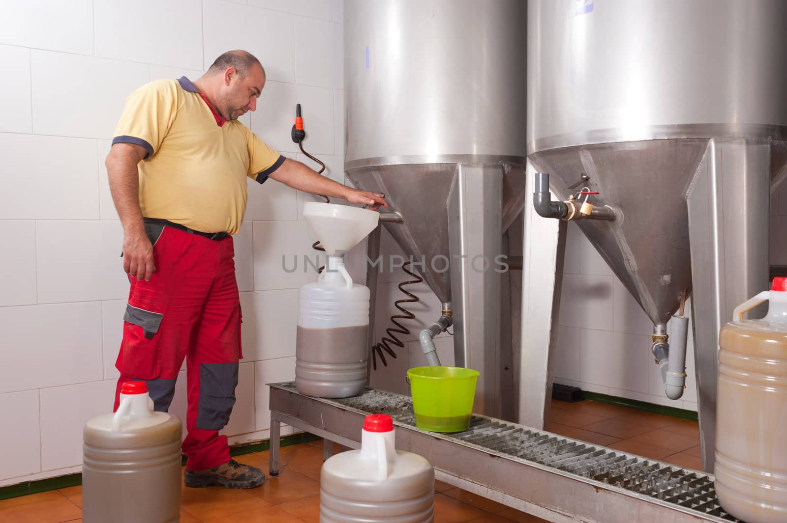 Farmer collecting the freshly pressed oil from his olive crop