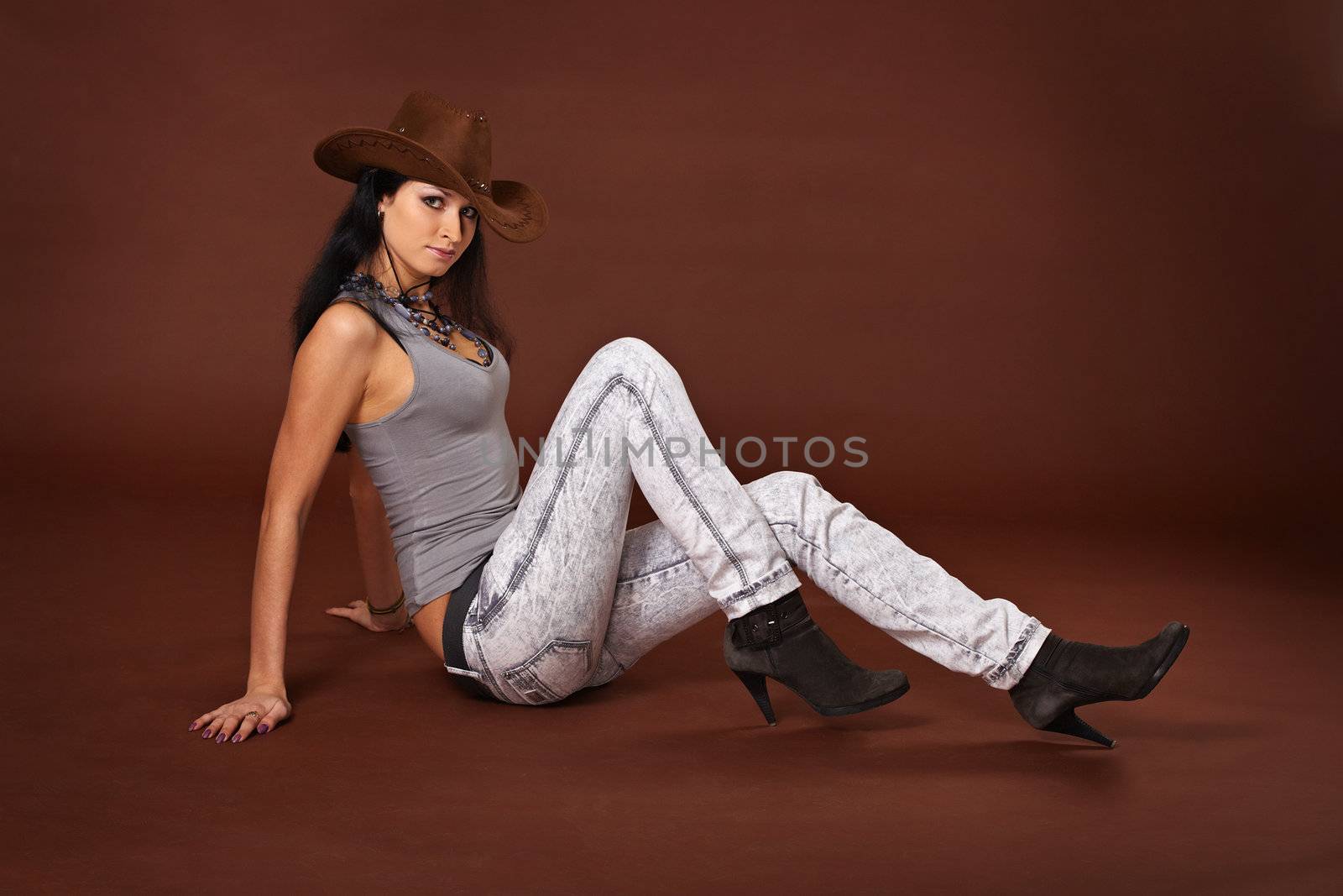 Young beautiful woman in a hat on a brown background
