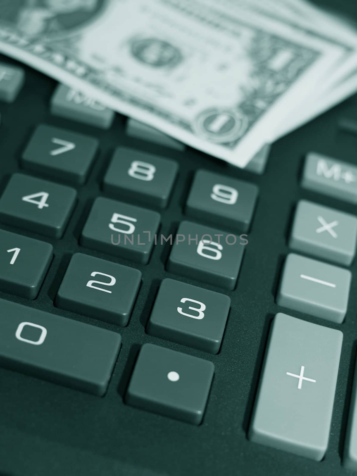 Money on keypad of a calculator close up