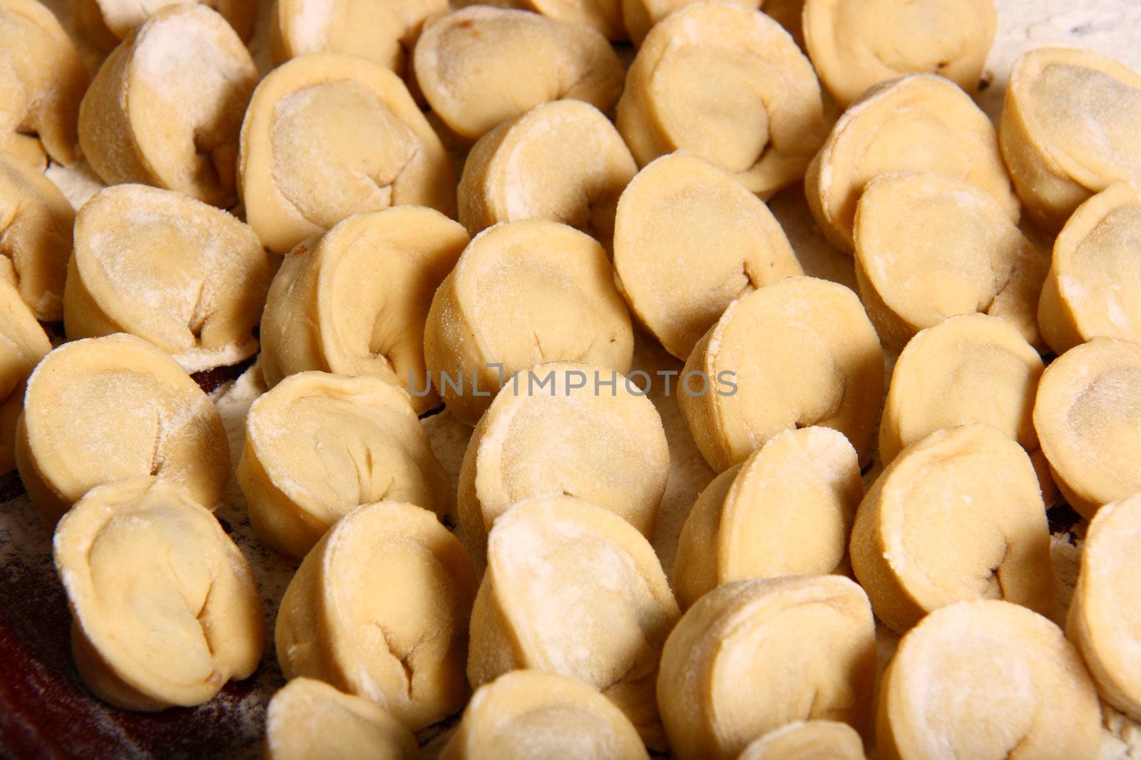 hand made ravioli getting prepared on table waiting for cooking