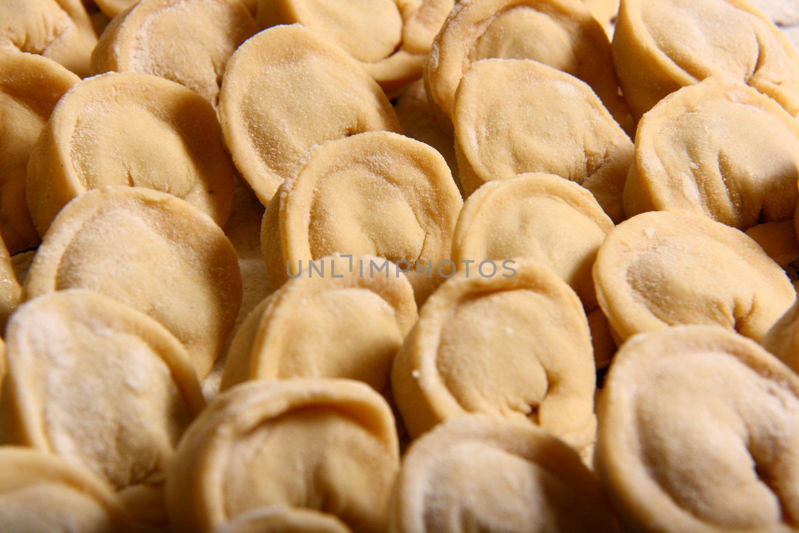 hand made ravioli getting prepared on table waiting for cooking