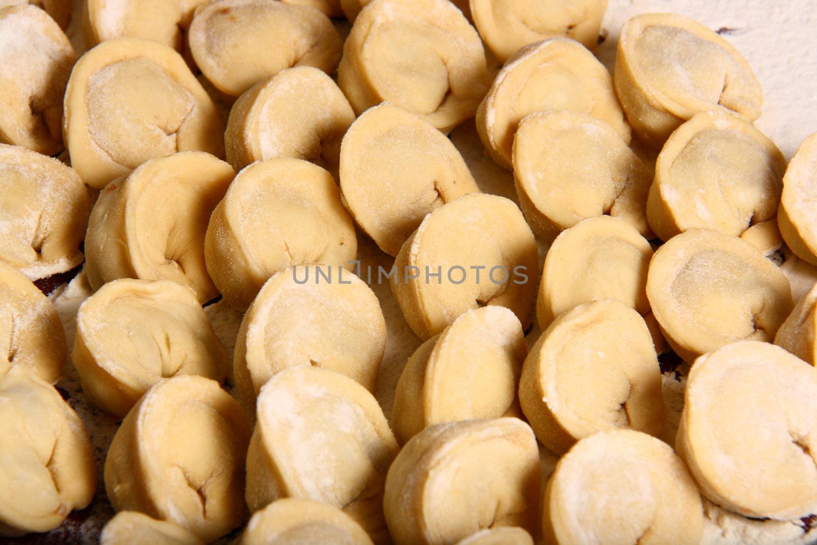 hand made ravioli getting prepared on table waiting for cooking