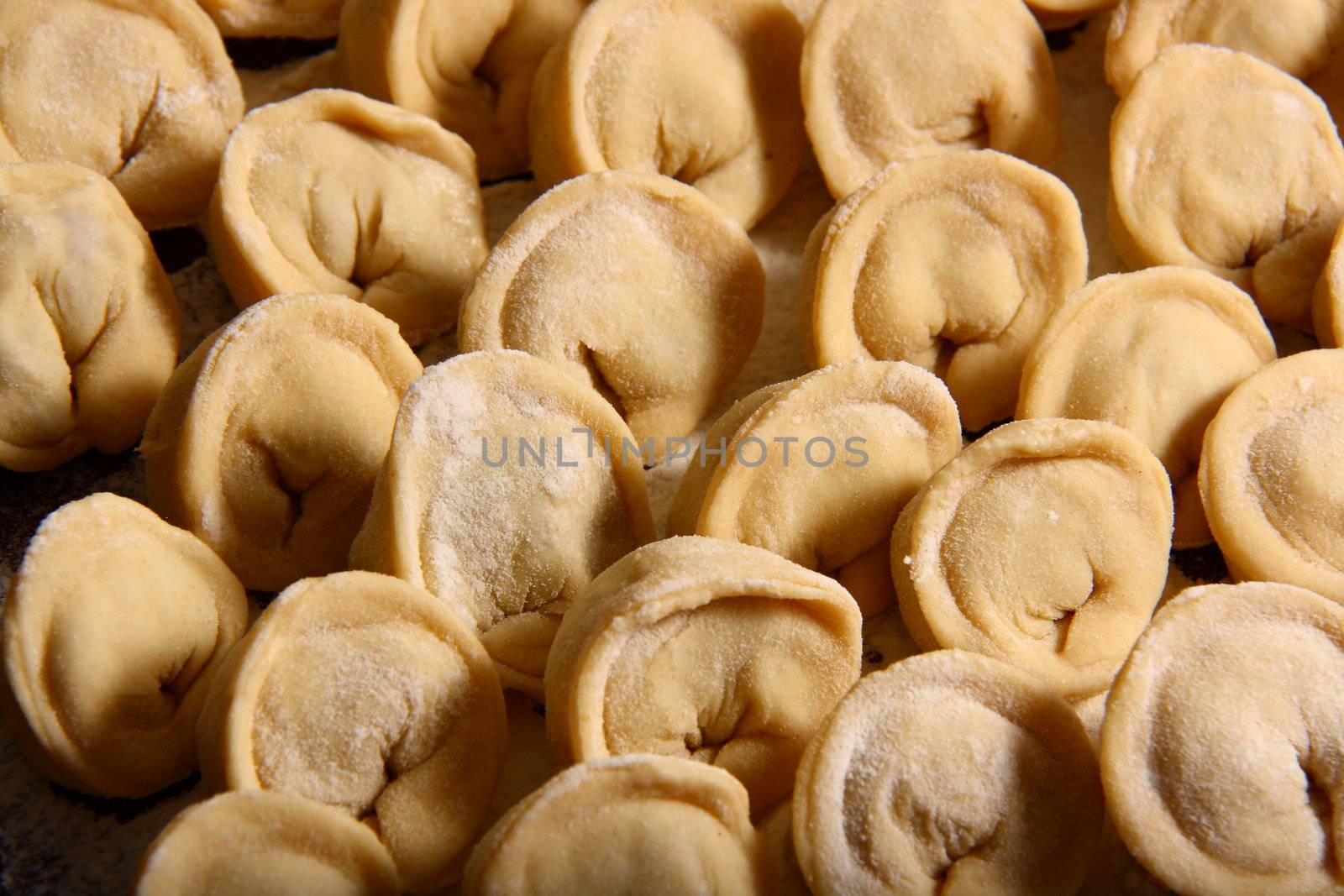 hand made ravioli getting prepared on table waiting for cooking