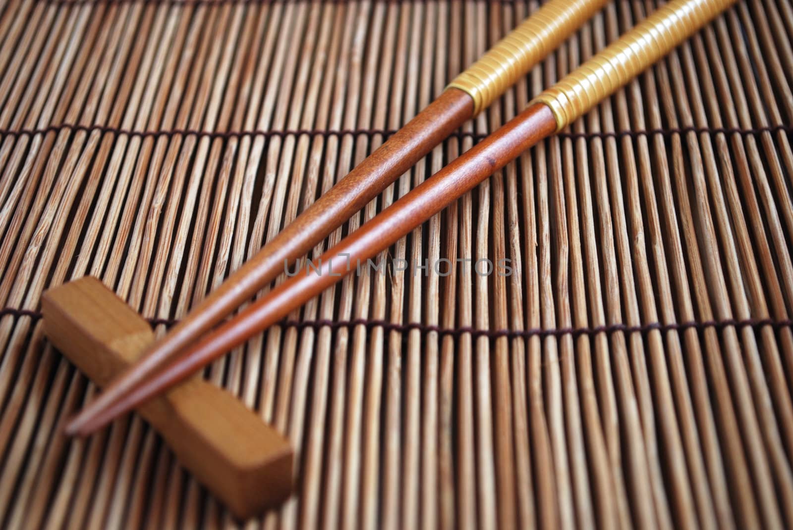 Chopsticks on brown bamboo matting background  