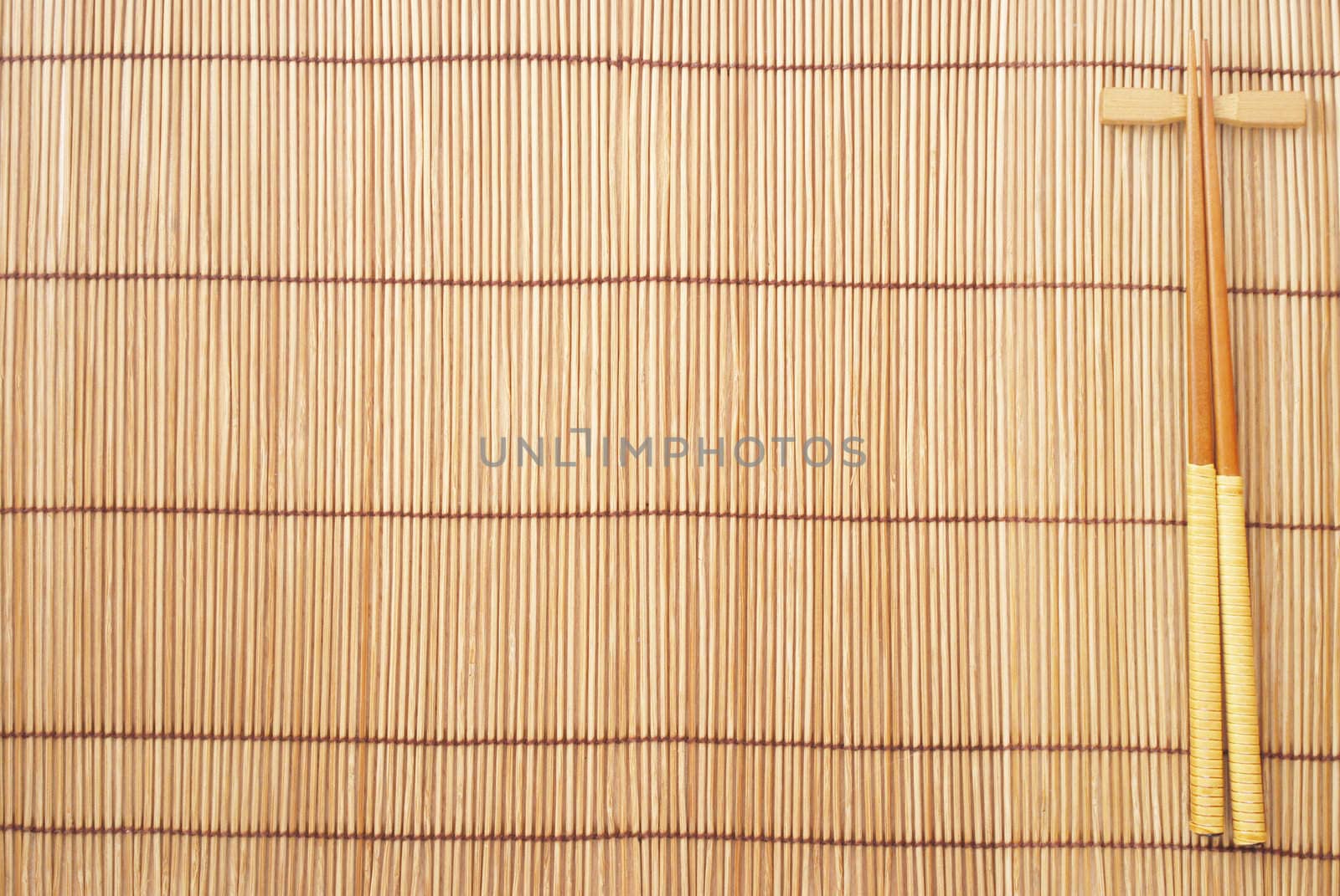 Chopsticks on brown bamboo matting background 