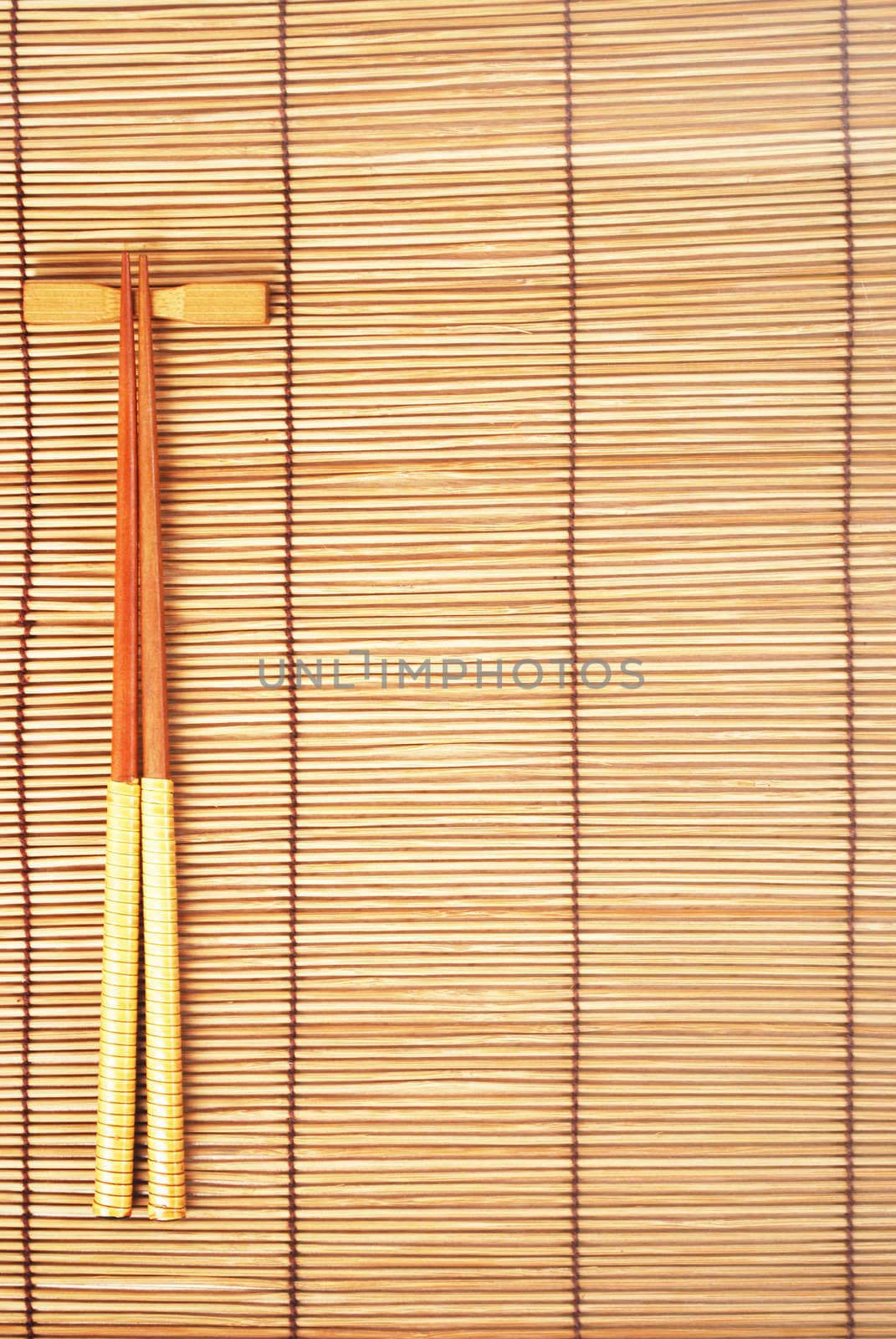 Chopsticks on brown bamboo matting background 