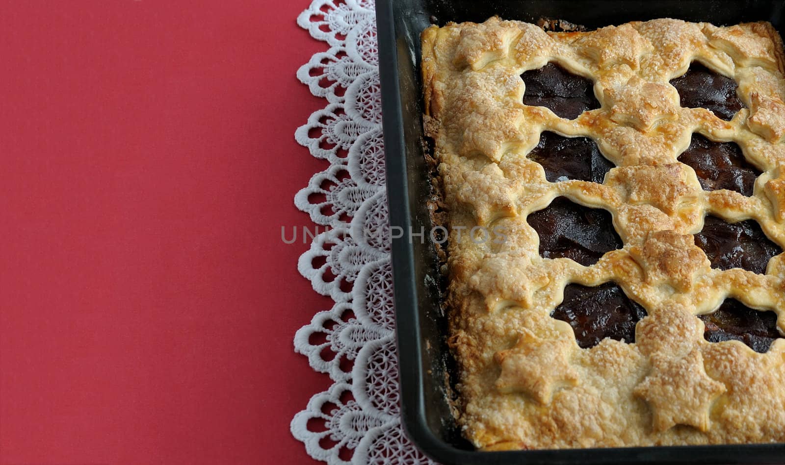 strudel stuffed with apples and jam on a red tablecloth with white laces