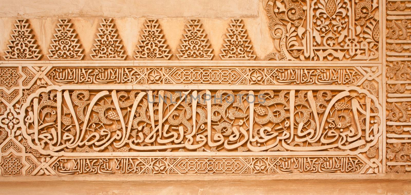 Arabic inscriptions on a wall in the Nasrid Palaces of the Alhambra of Granada, Spain.