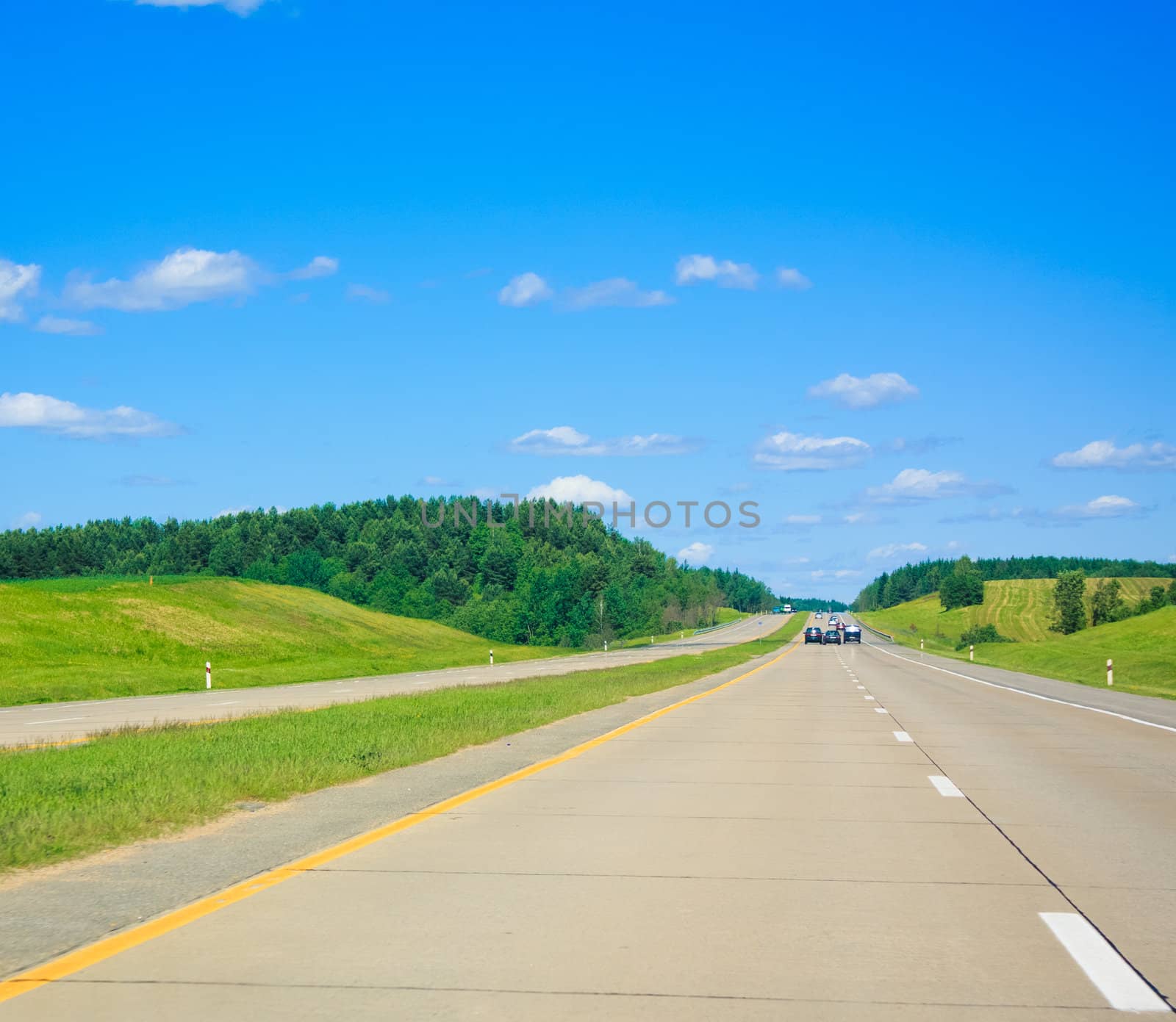 Long road in front of blue sky and mountains