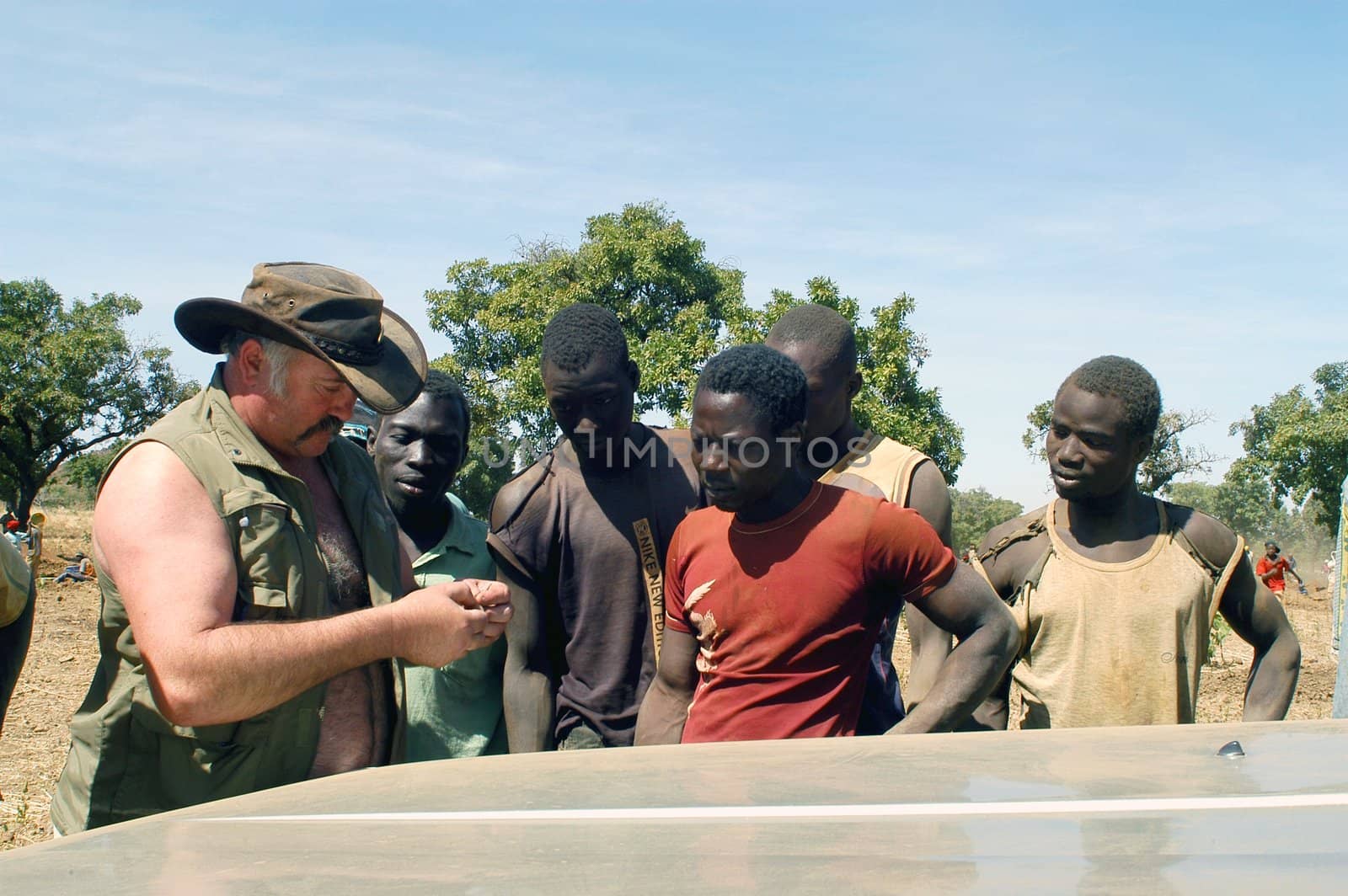 At the goldmine of Poura a French arrived and seeks to buy gold nuggets at the best price. Discussed are sharp and the cap of the car serves as office. The minors encircles the white man.                               