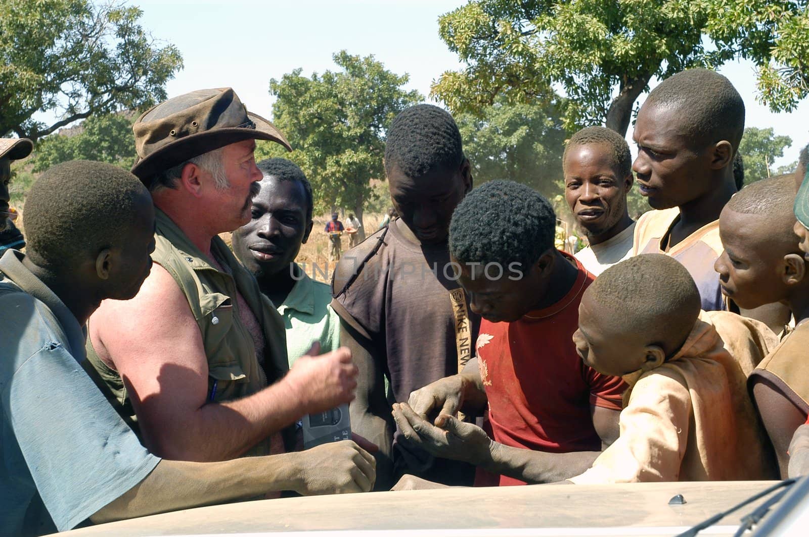 At the goldmine of Poura a French arrived and seeks to buy gold nuggets at the best price. Discussed are sharp and the cap of the car serves as office. The minors encircles the white man.                               
