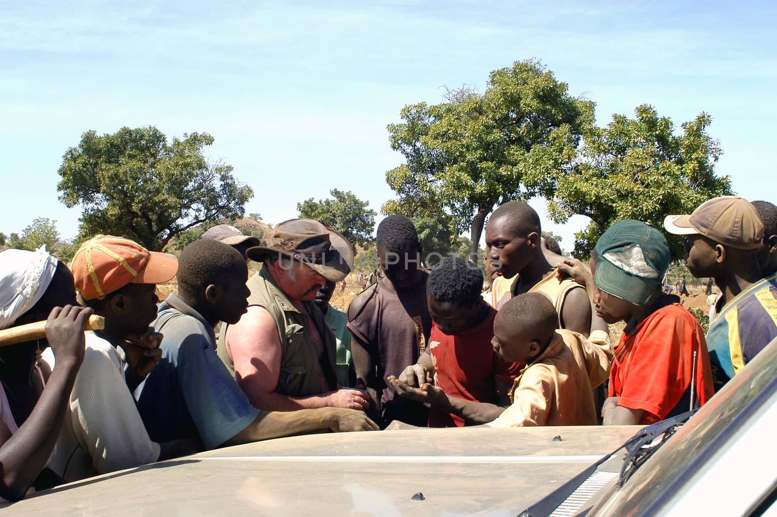 At the goldmine of Poura a French arrived and seeks to buy gold nuggets at the best price. Discussed are sharp and the cap of the car serves as office. The minors encircles the white man.                               