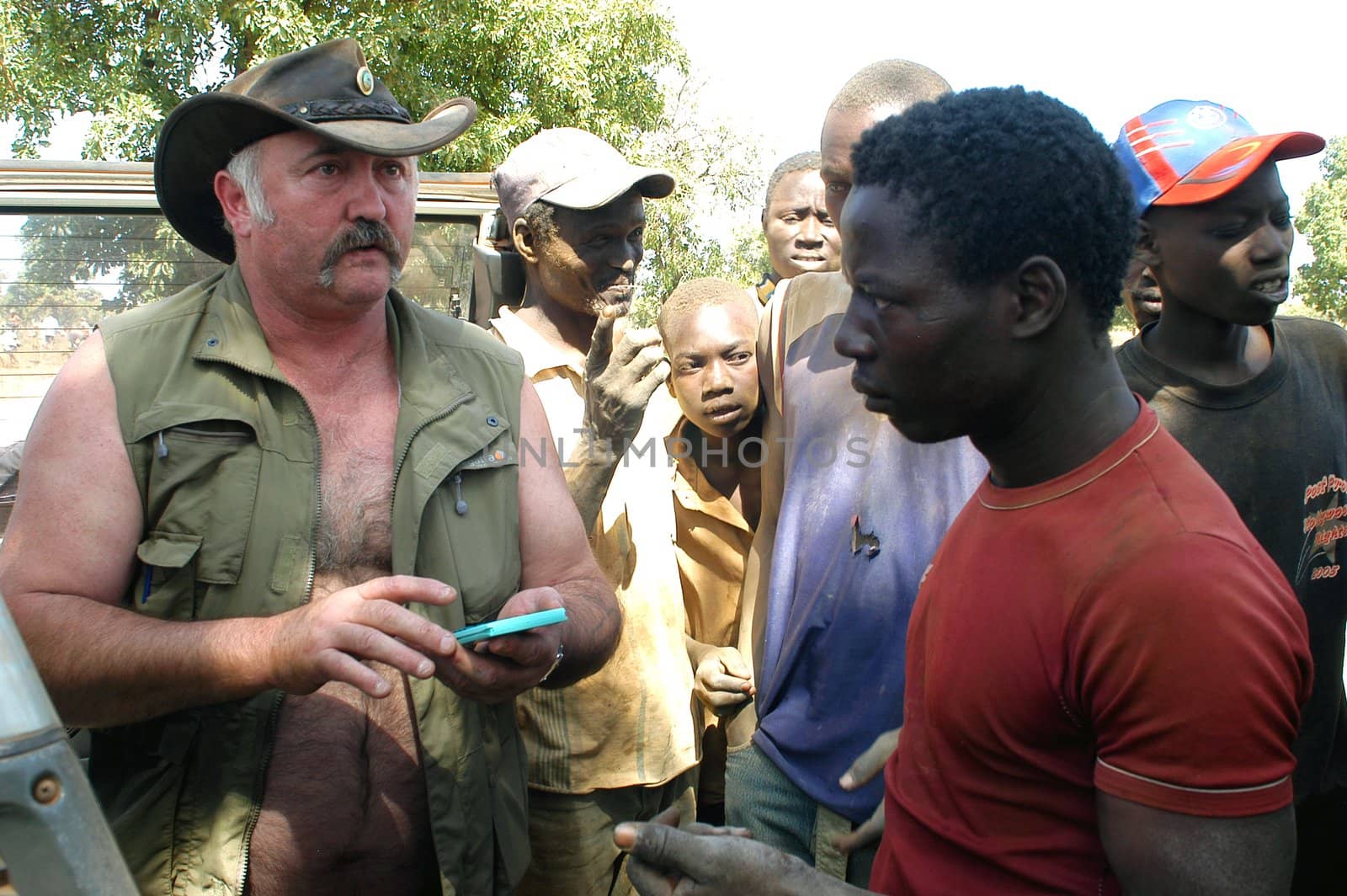 At the goldmine of Poura a French arrived and seeks to buy gold nuggets at the best price. Discussed are sharp and the cap of the car serves as office. The minors encircles the white man.                               