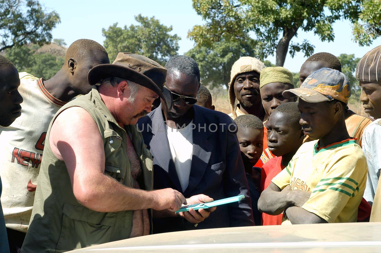 At the goldmine of Poura a French arrived and seeks to buy gold nuggets at the best price. Discussed are sharp and the cap of the car serves as office. The minors encircles the white man.                               