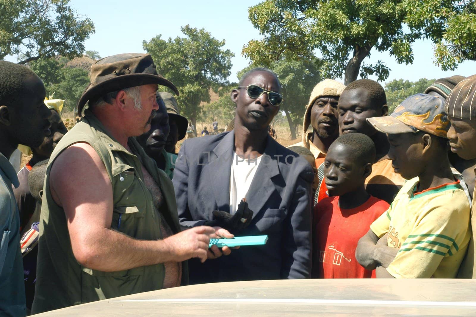 At the goldmine of Poura a French arrived and seeks to buy gold nuggets at the best price. Discussed are sharp and the cap of the car serves as office. The minors encircles the white man.                               