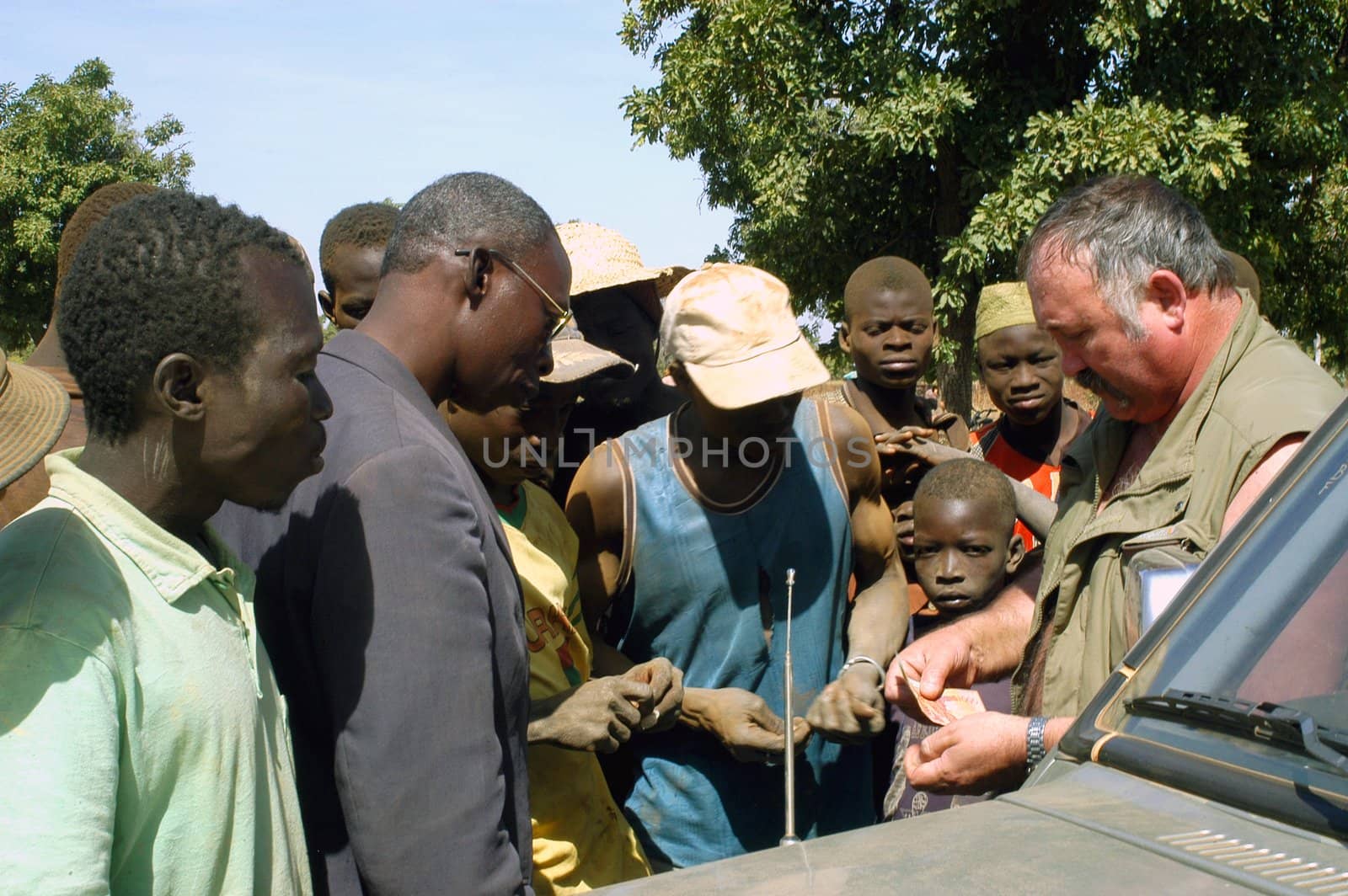 At the goldmine of Poura a French arrived and seeks to buy gold nuggets at the best price. Discussed are sharp and the cap of the car serves as office. The minors encircles the white man.                               