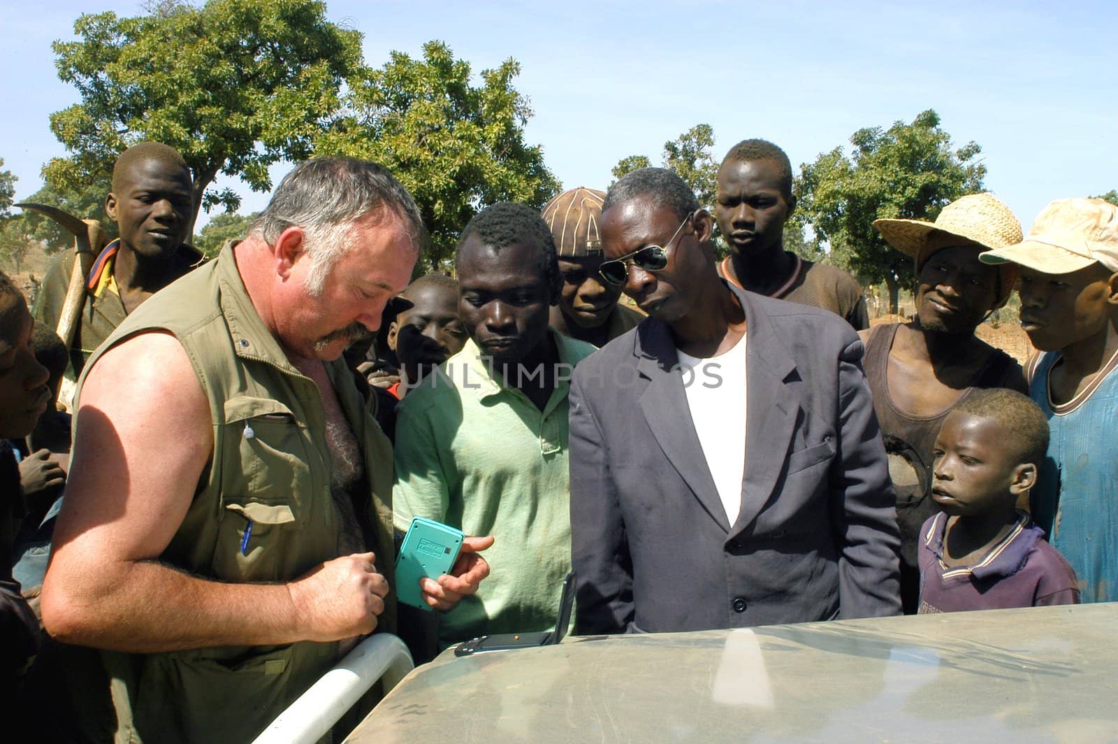 At the goldmine of Poura a French arrived and seeks to buy gold nuggets at the best price. Discussed are sharp and the cap of the car serves as office. The minors encircles the white man.                               