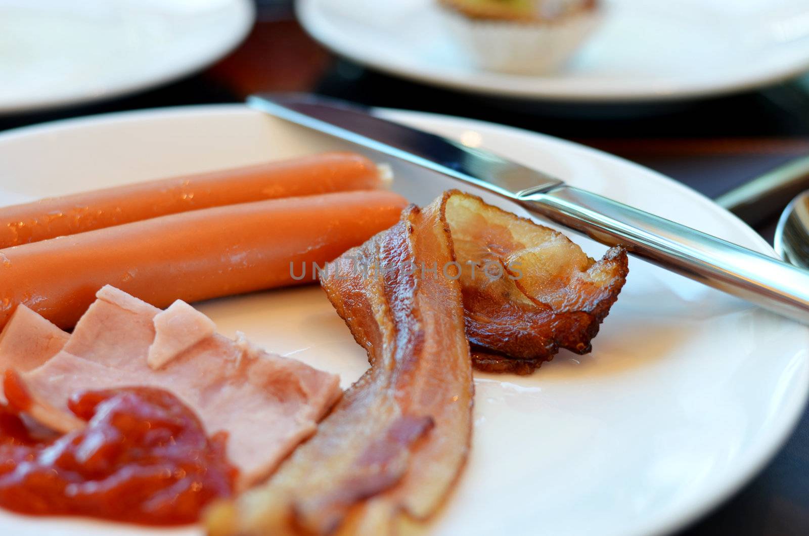 Breakfast with bacon, ham , sausage and  tomato sauce
