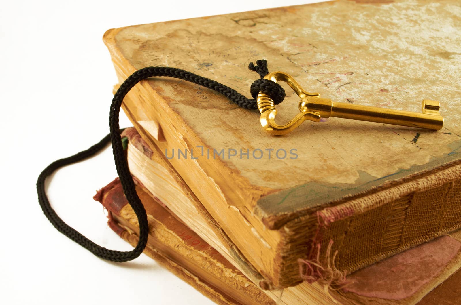 Golden key on old books isolated on white background