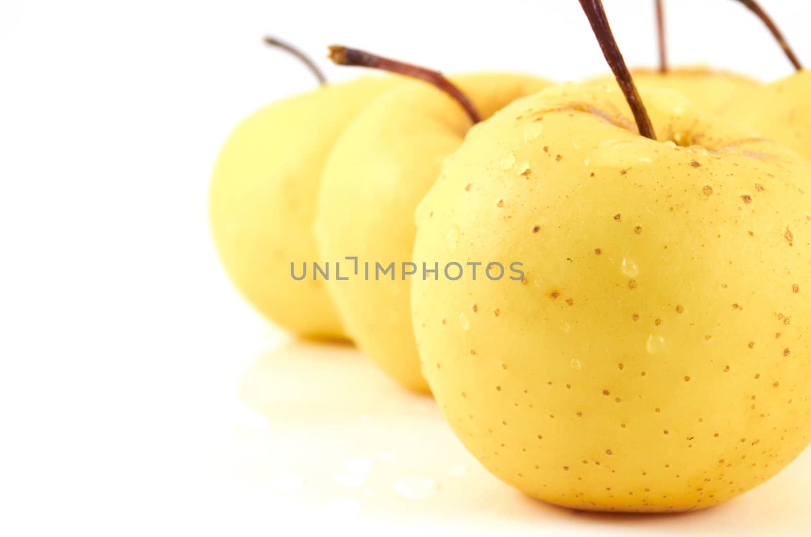 Juicy apples in drops of water on a white background