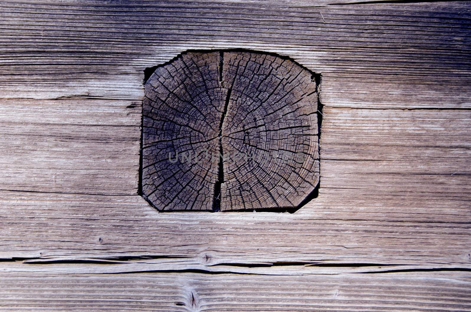 Closeup of ancient wooden house wall fragment. Architecture made of logs and planks.