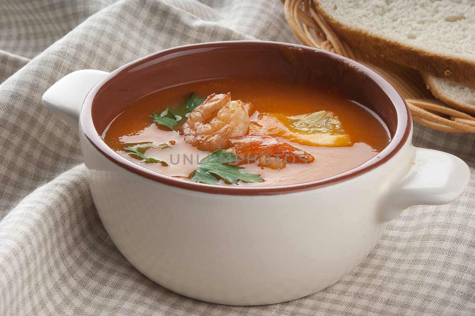 Tomato soup with shrimps, lemon and parsley in the bowl